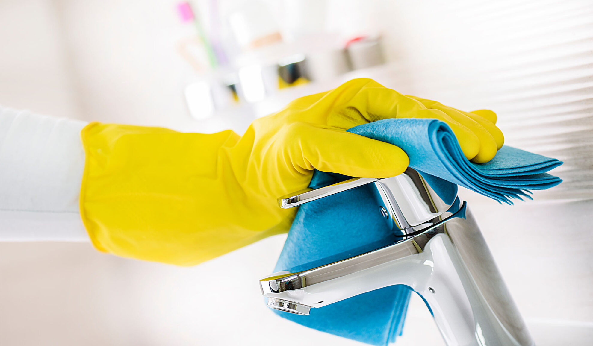 hand close up cleaning bathroom fixtures with cloth madison wi